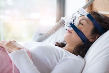 Woman and cpap mask, healthcare concept.Senior woman using cpap machine to stop choking and snoring...