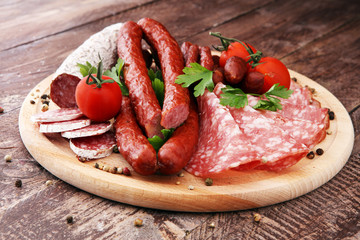 Food tray with delicious salami, pieces of sliced ham, sausage, tomatoes, salad and vegetable - Meat platter with selection - Cutting sausage and cured meat
