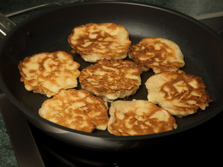 Apple pancakes in black frying pan