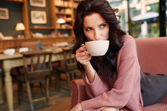 pretty woman drinking coffee in a cafe. Pleasure time