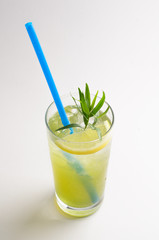 Tarragon lemonade with lemon in a glass on white background