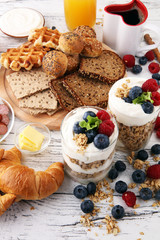 Breakfast served with coffee, orange juice, bread, parfaits and fruits. Balanced diet