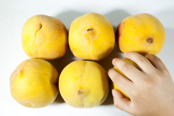 Group of organic peaches in Guatemala, seasonal fruit. Prunus persica. Hand of boy grabbing peach