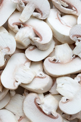 Fresh white champignons (mushrooms), sliced, uncooked, background, full