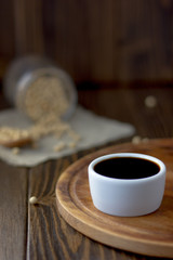 White ceramic bowl with soy sauce on kitchen.