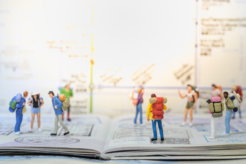 Travel concepts. Group of traveler miniature mini figures with backpack stand and walking on passport with immigration stamps with map as background