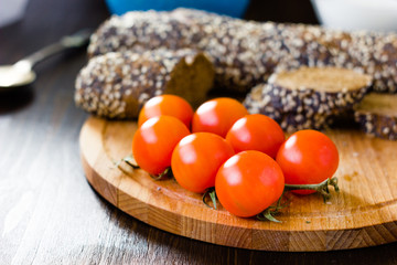 Hip of cherry tomatoes over the wooden board.