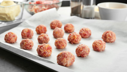 Baking tray with tasty sausage cheese balls on table