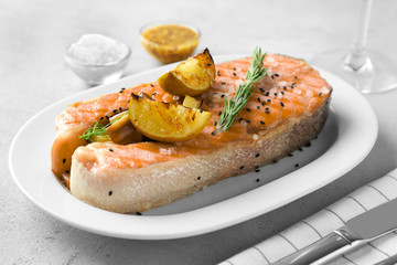 Plate with delicious salmon steak on table