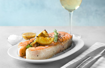 Plate with delicious salmon steak on table