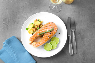 Plate with delicious salmon steak on table