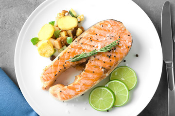 Plate with delicious salmon steak on table