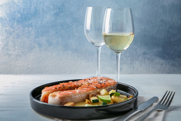 Plate with delicious salmon steak on table