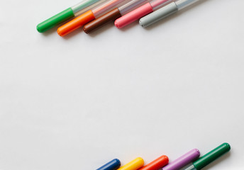 A set of markers on a sheet of white paper. Top view. Concept. Drawing of different colors