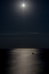 Fototapeta na wymiar Moon reflecting in a sea, night time, moon path, clear night
