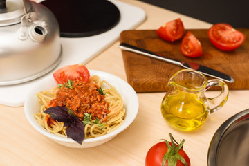 Spaghetti bolognese with olive oil, tomatoes and basil in toy kitchen