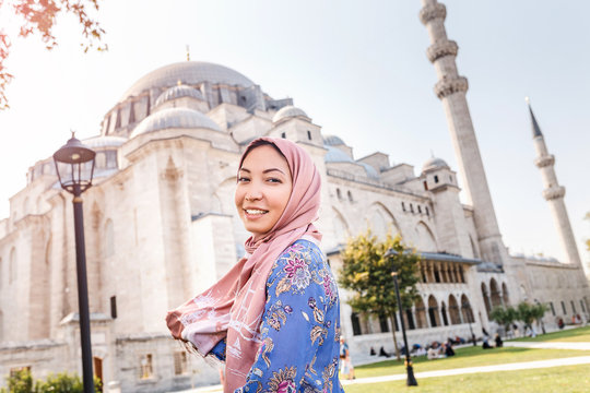 Happy attractive muslim woman in Istanbul, Turkey, posing in courtyard of Suleymaniye mosque, religion and travel concept.