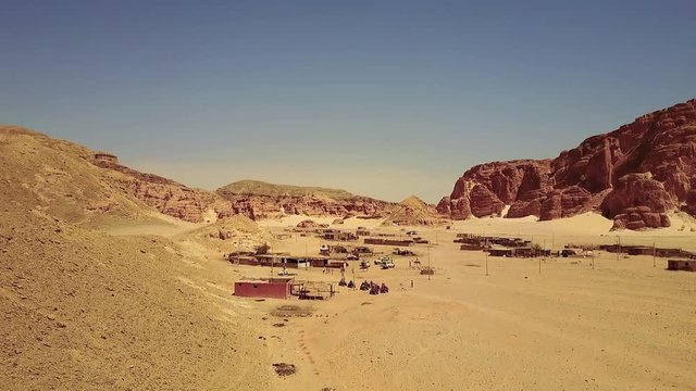 Bedouin village in Sahara desert on mountain landscape. Desert Bedouin Camp Skyline Aerial shot