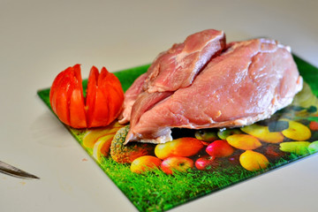 Raw pork on cutting board and vegetables