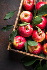 Red apples in wooden tray.