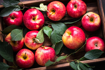 Red apples in wooden tray.