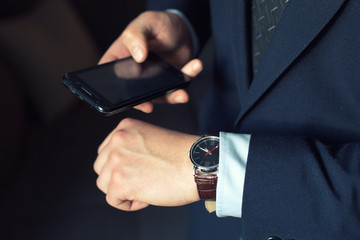 young businessman in dark office with smartphone tablet and credit card