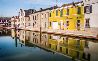 Fototapeta na wymiar houses and reflections over a canal in Italy