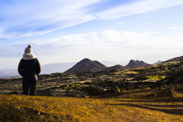 Girl with white hat and scarf watching Icelandic mountains 