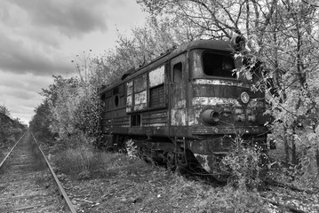 Naklejka na ściany i meble Hopeless post apocalyptic landscape. Cemetery of abandoned broken trains. Monochrome photo.