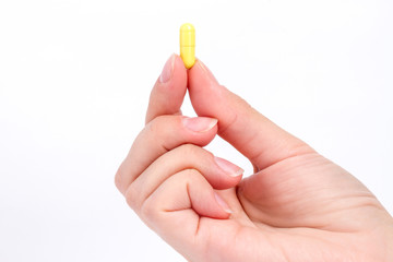 doctor's hand holds the yellow capsule close-up