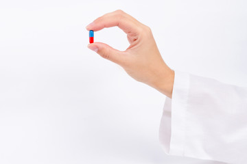 Fototapeta premium hand of nurse doctor holding blue and red capsule