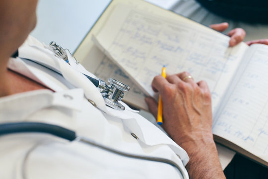 Doctor making notes on a patient folder