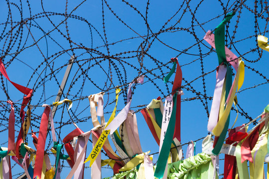 colourful ribbons tied at barbed wire at a fence at the demilitarised zone DMZ at the freedom bridge, South Korea, Asia