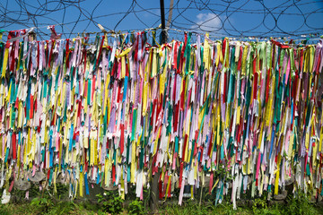 Colorful peace prayer ribbons tied at a fence at the demilitarised zone DMZ at the freedom bridge, South Korea, Asia