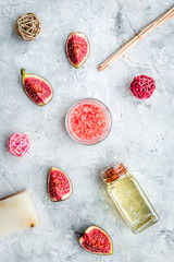 organic cosmetic set with fresh fig, bath salt, oil and scrub on stone background flat lay