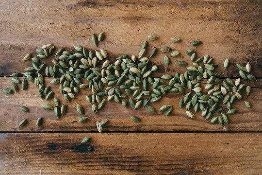 Cardamom pods scattered on a wooden table