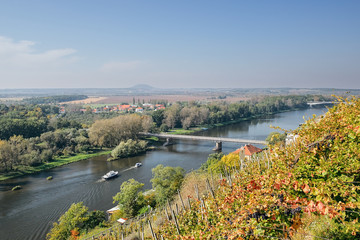 Obraz premium Two ships floating near bridge over european river Labe when viewed from lookout in Melnik city in autumnal czech landscape