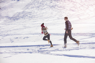 Carefree happy young couple having fun together in snow.