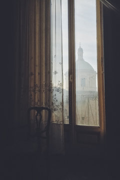 Old interior against window and Church in Italy