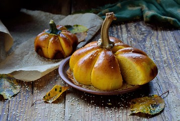 Pumpkin bread with sesame seeds on ceramic plate and on  baking paper