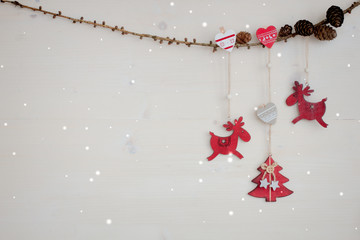 Christmas Garland with red wooden deer, hearts, Christmas-tree and cones.