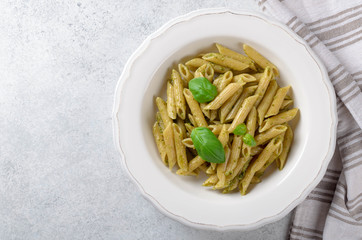 Whole wheat Pasta with homemade pesto sauce in a white plate on