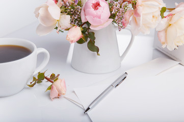 Letter, pen and white envelope, cup of coffe and present on white background with pink english rose. Invitation cards or love letter. Birthday, Mother's, Valentines, Women's, Wedding Day concept