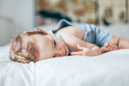 Baby relaxing on a white bed