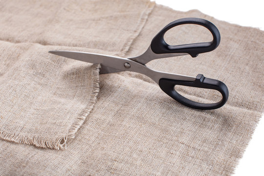 The Tailor's Scissors Cut Linen Fabric On A White Background.