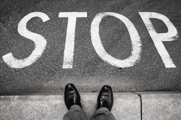 Fototapeta premium Feet of a man and stop road marking label