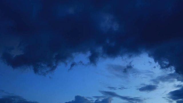 time-lapse moving black clouds above dusk sky