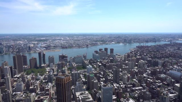 Aerial daytime establishing shot overlooking Brooklyn across the East River from midtown Manhattan.