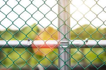 Sunlight shining through gate with steel grid