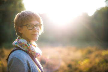 Young woman looking into camera in sunset light